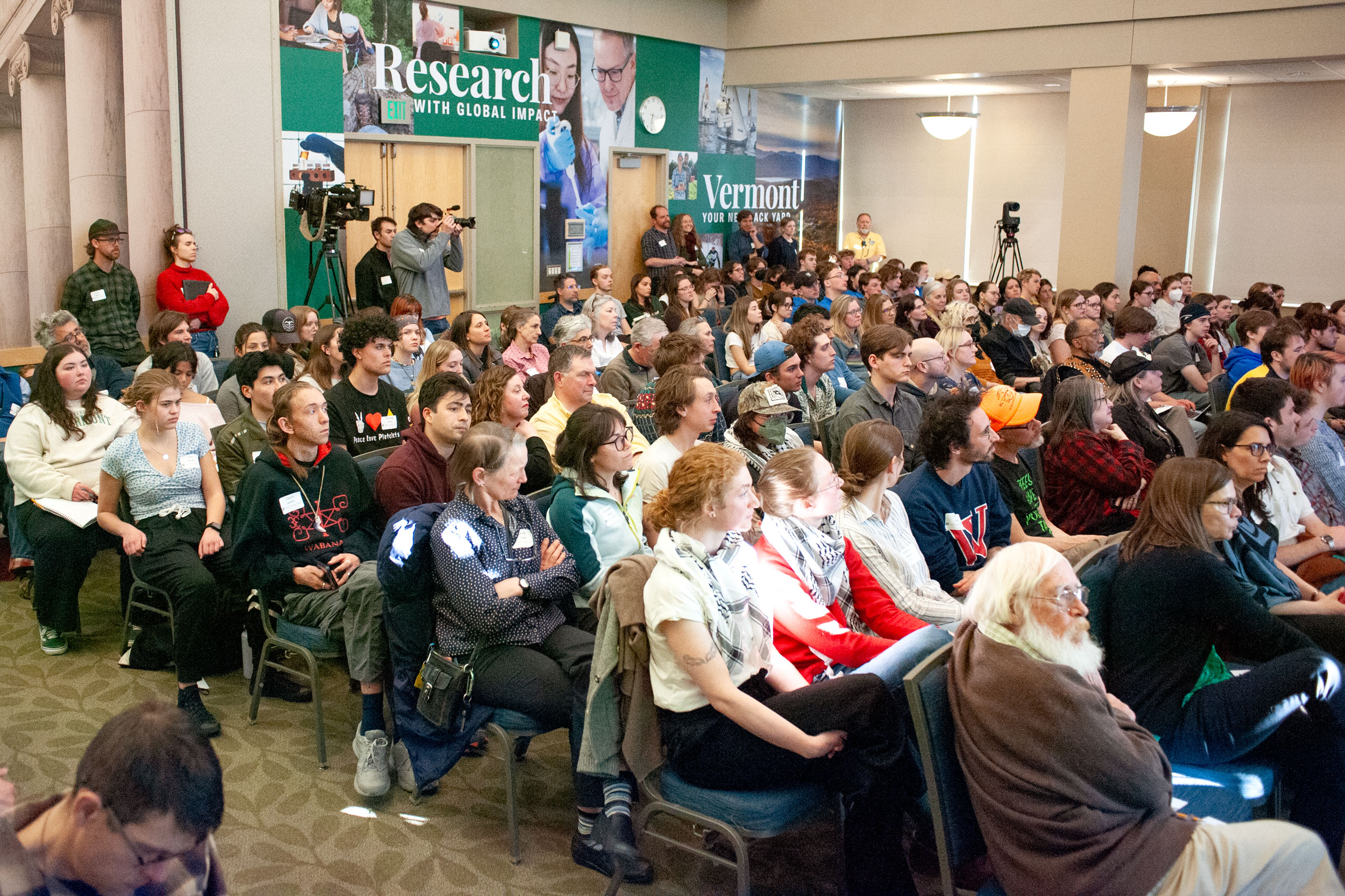 A large crowd sitting in chairs looking at a presentation.