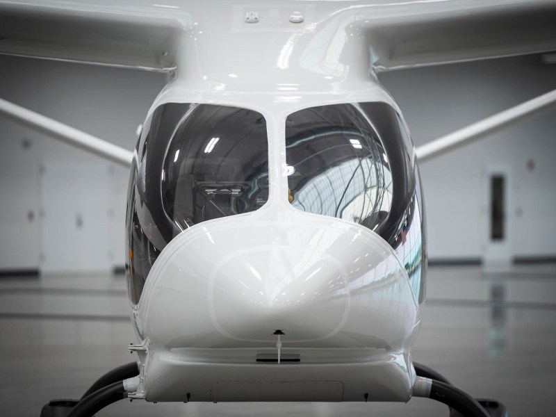 A small white airplane parked in a hangar.