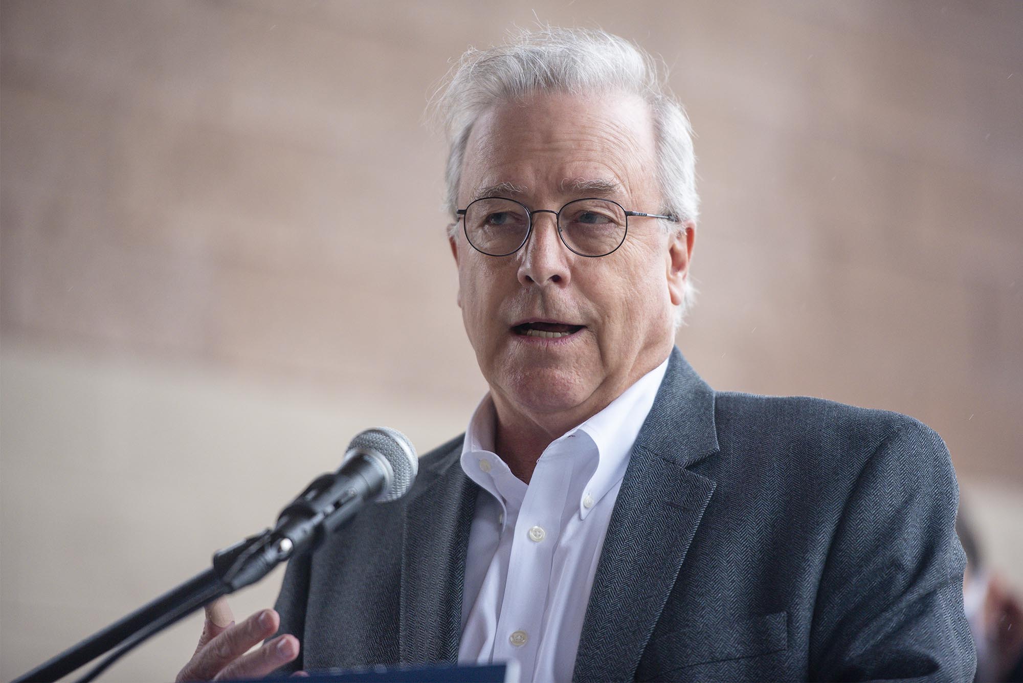 A man speaking into a microphone at a public event.