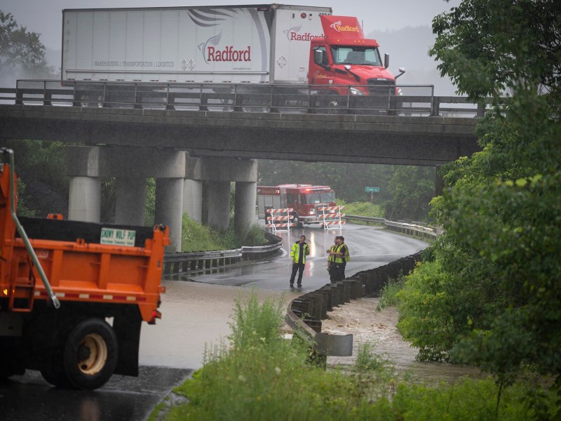 a truck is stopped on a bridge in the rain.
