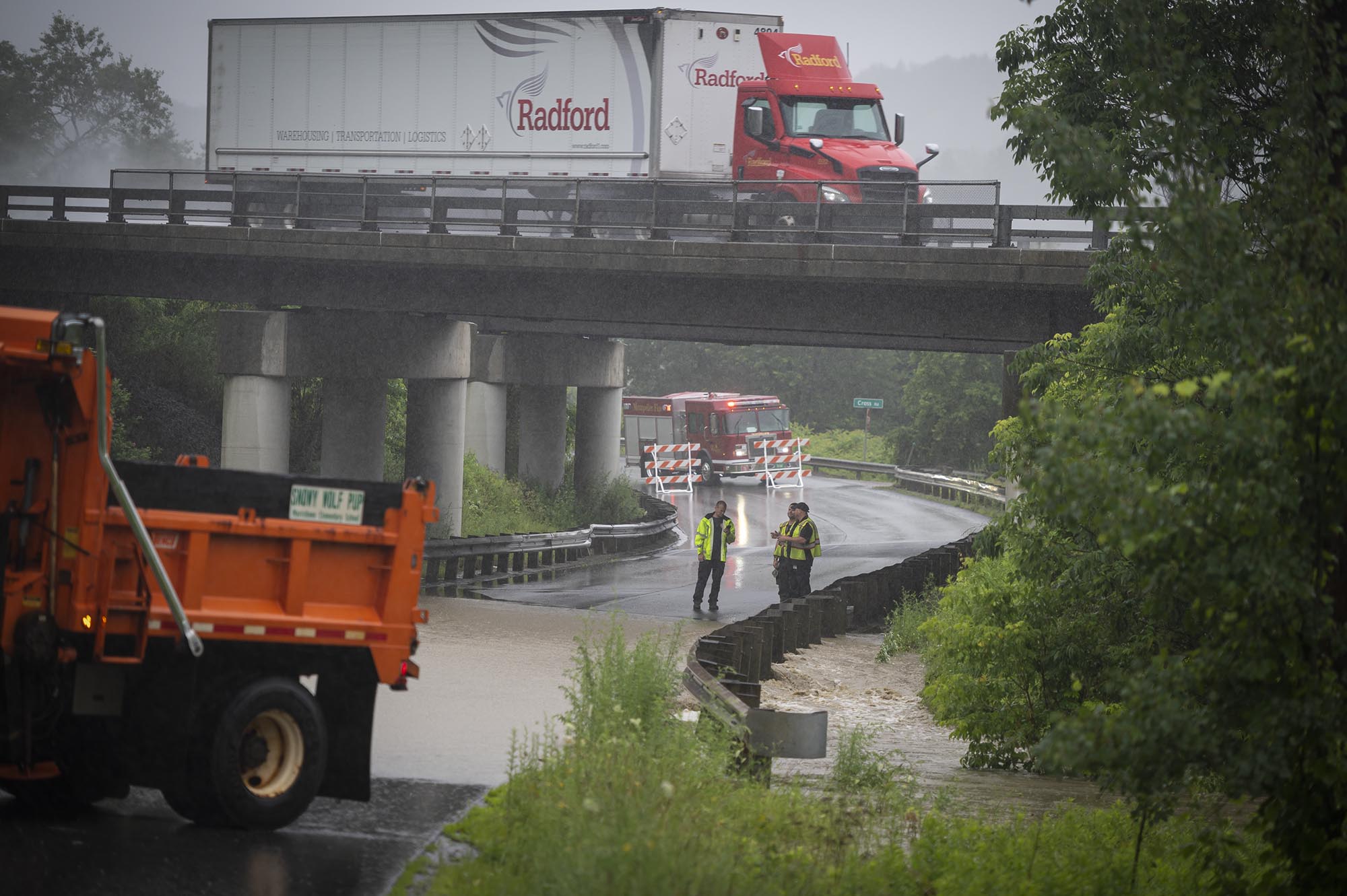 a truck is stopped on a bridge in the rain.