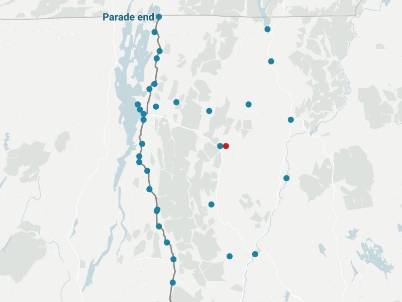 A map with blue dots along a route labeled “Parade end” at the top; one red dot appears among the blue dots, with pale landscape features in the background.