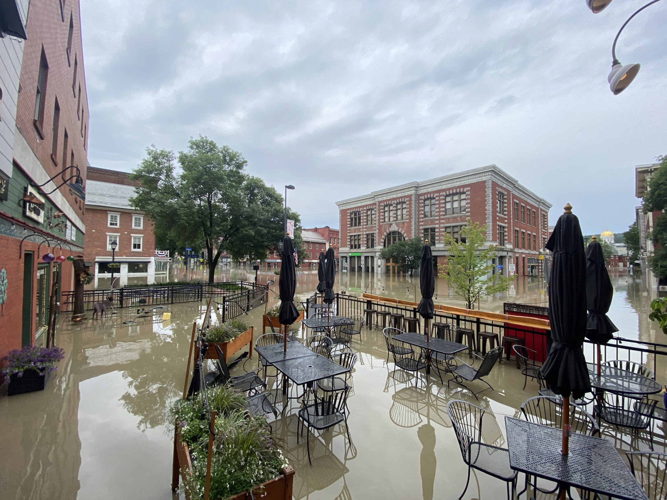 a flooded street with tables and chairs.