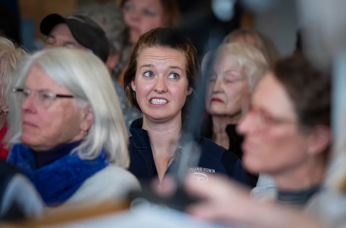 A woman looking surprised or concerned in a crowded room.
