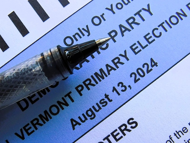 Close-up of a ballot indicating the Democratic Party for the Vermont primary election on August 13, 2024, with a pen pointing towards the written text.
